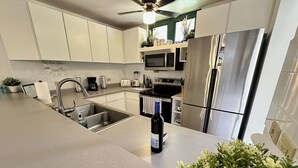A modern kitchen with stainless steel appliances, a built-in oven, and a large refrigerator. - Enjoy the beautiful beach villa of Boqueron. Relax in stress-less beach ambiance (Boquerón)