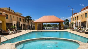 A swimming pool with a sunken center, surrounded by lounge chairs and a covered pavilion. - Enjoy the beautiful beach villa of Boqueron. Relax in stress-less beach ambiance (Boquerón)