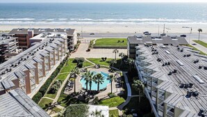 A hotel with multiple buildings, a swimming pool, and a beach view. - Sassy Seahorse - FRONT ROW - Beach Views 8 Guests (Galveston)