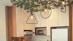 Een moderne keuken met houten kastjes, een centraal eiland met barstoelen en hanglampen.