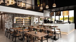A modern restaurant with a stone wall, wooden tables, and hanging pendant lights. - Modern Island Getaway with Heated pool added fee, Bar & Gazebo (Gilbert)