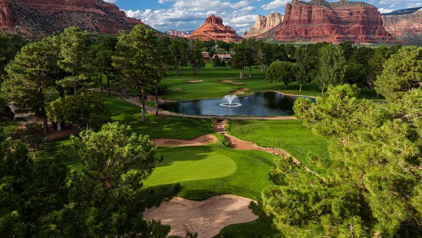 A golf course with a pond, surrounded by trees and red rock formations. - Sedona Gecko Retreat: Luxurious 4BR home with red rock views and private pool. (Sedona)
