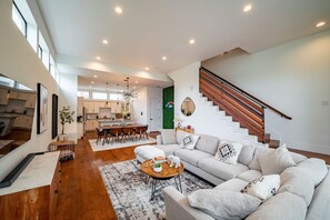 Un vaste espace de vie comprenant un canapé, une table basse et un escalier.