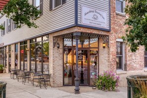 A corner building with a sign reading "Something Brewing." It has large windows and outdoor seating.