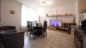Uma cozinha moderna com área de refeições, televisão e forno embutido.
