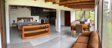Un interior moderno con una mesa de comedor de madera, un sofá y una zona de cocina.