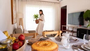 Un salon avec une table à manger, un téléviseur et une plante en pot.