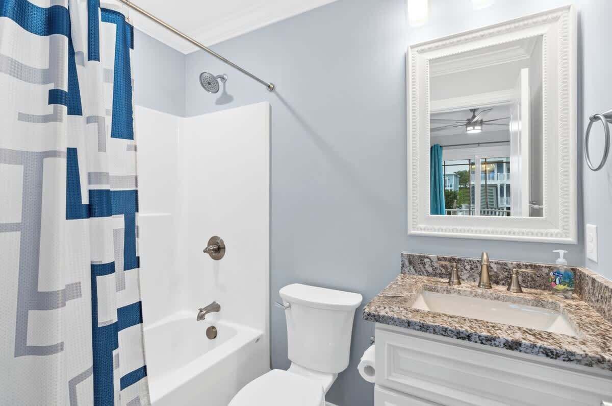 Une salle de bain équipée d’une douche, de toilettes, d’un lavabo et d’un miroir.