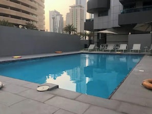 Piscina com espreguiçadeiras e um salva-vidas.