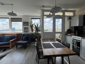 A modern kitchen with a dining area, large windows, and a view of the city. - Fantastic View over London apartment in Abbey Road (London)