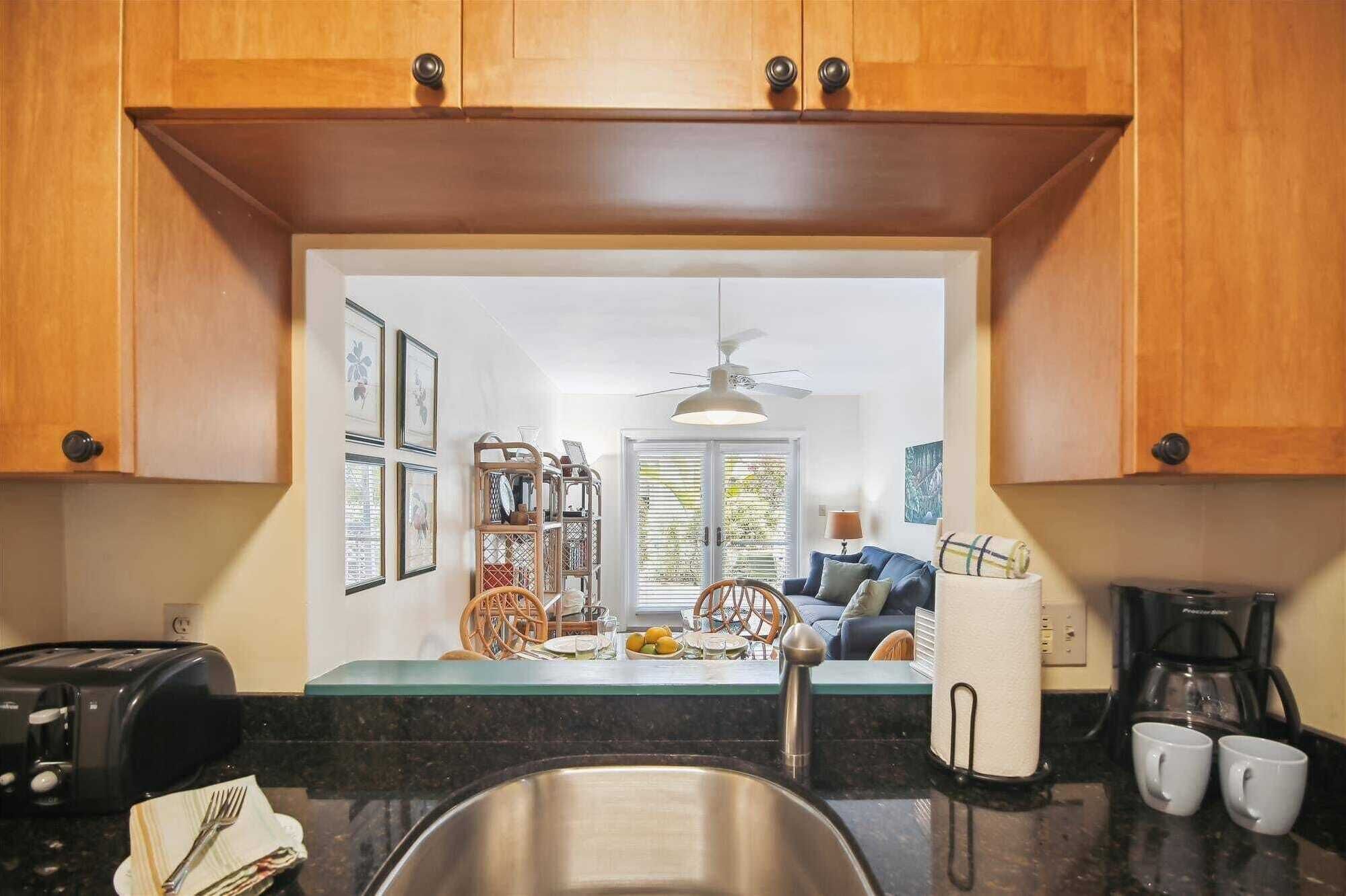 A kitchen with wooden cabinets, a stainless steel sink, a toaster, and a coffee maker.