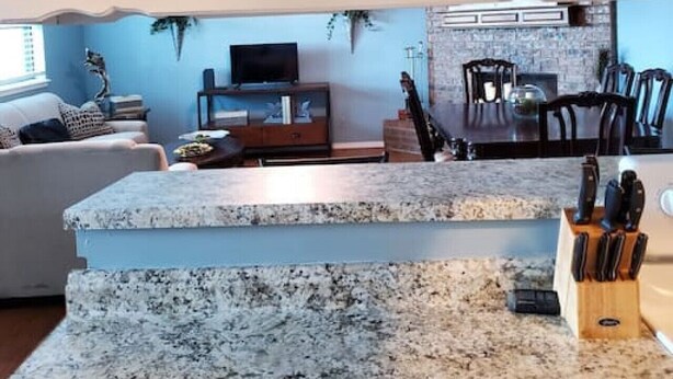 A kitchen with granite countertops, a knife block, and a dining area with chairs and a table. - OKC - Curtis · Self Check-in-King-Fast wifi-20min 2 anywhere (Oklahoma City)