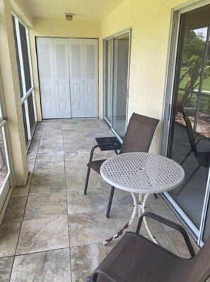 Relax in this serene outdoor space with a comfortable seating area and glass door leading to a covered patio.