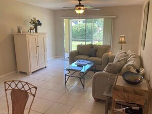 Relax in this inviting living area with a sofa set, coffee table, and wicker chair.