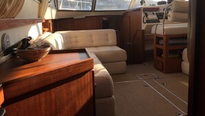 Un interior acogedor con una zona de estar con cojines, una mesa de madera con una cesta y un panel de control.