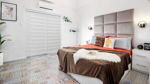 A modern bedroom with a large bed, a grey headboard, and a patterned rug. - Hyllia by J&J ( Near Airport| Wi-Fi | Netflix )  (Lapu-Lapu City)