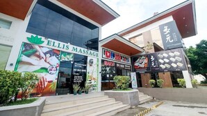 A building with a massage center named 'Ellis Massage' and a food store with Asian cuisine. - Hyllia by J&J ( Near Airport| Wi-Fi | Netflix )  (Lapu-Lapu City)