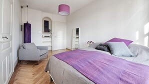 A bedroom with a bed, a chair, a wardrobe, and a mirror. - Am Pavillon Bed & Kitchen (Bern)