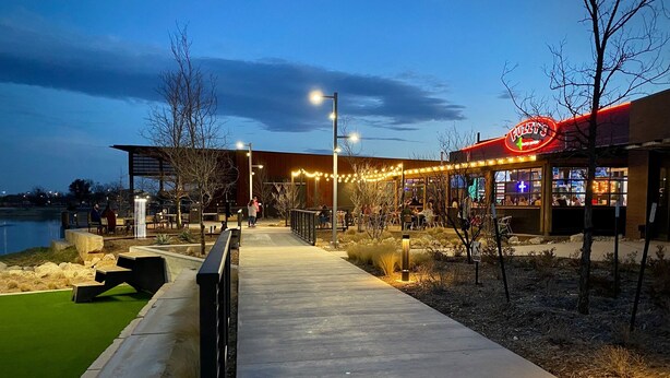 Un restaurante frente al agua con terraza al aire libre y un paseo marítimo que lo conecta.