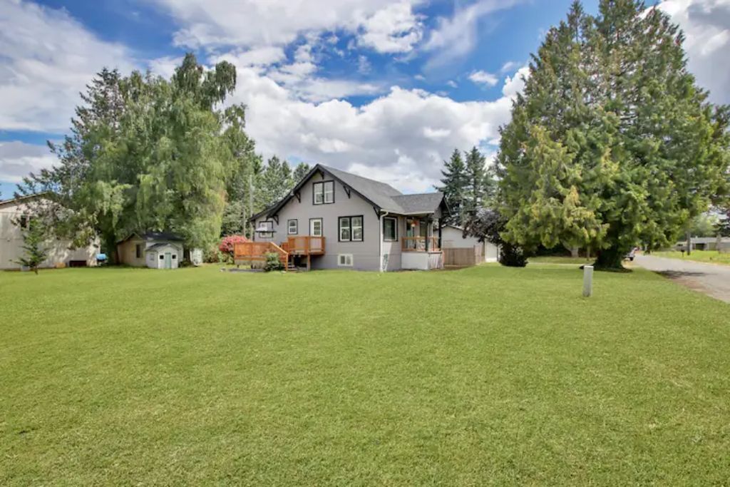 A two-story house with a large front yard, a covered porch, and a garage.