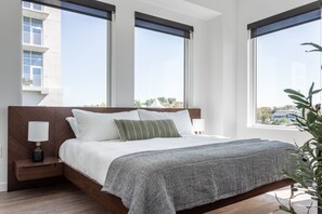 Premium bedding, memory-foam beds, laptop workspace, iron/ironing board