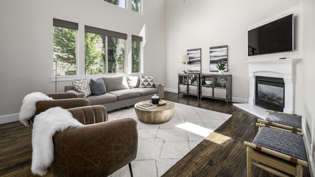 A spacious living room with a high ceiling, large windows, a fireplace, and a flat-screen TV. - Clean, modern, golf course home w/ incredible mtn views, close to hike/golf/ski. (Pleasant Grove)