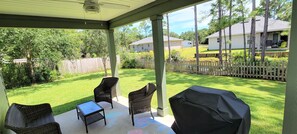 Relax in a peaceful backyard setting with a comfortable patio area and lawn.