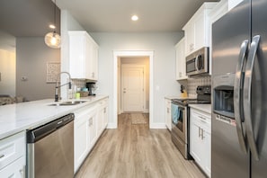 Kitchen features a dishwasher, microwave, oven, and refrigerator, with a no smoking sign.