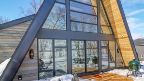 Un bâtiment moderne de forme triangulaire, doté de grandes fenêtres et d’une façade en bois.