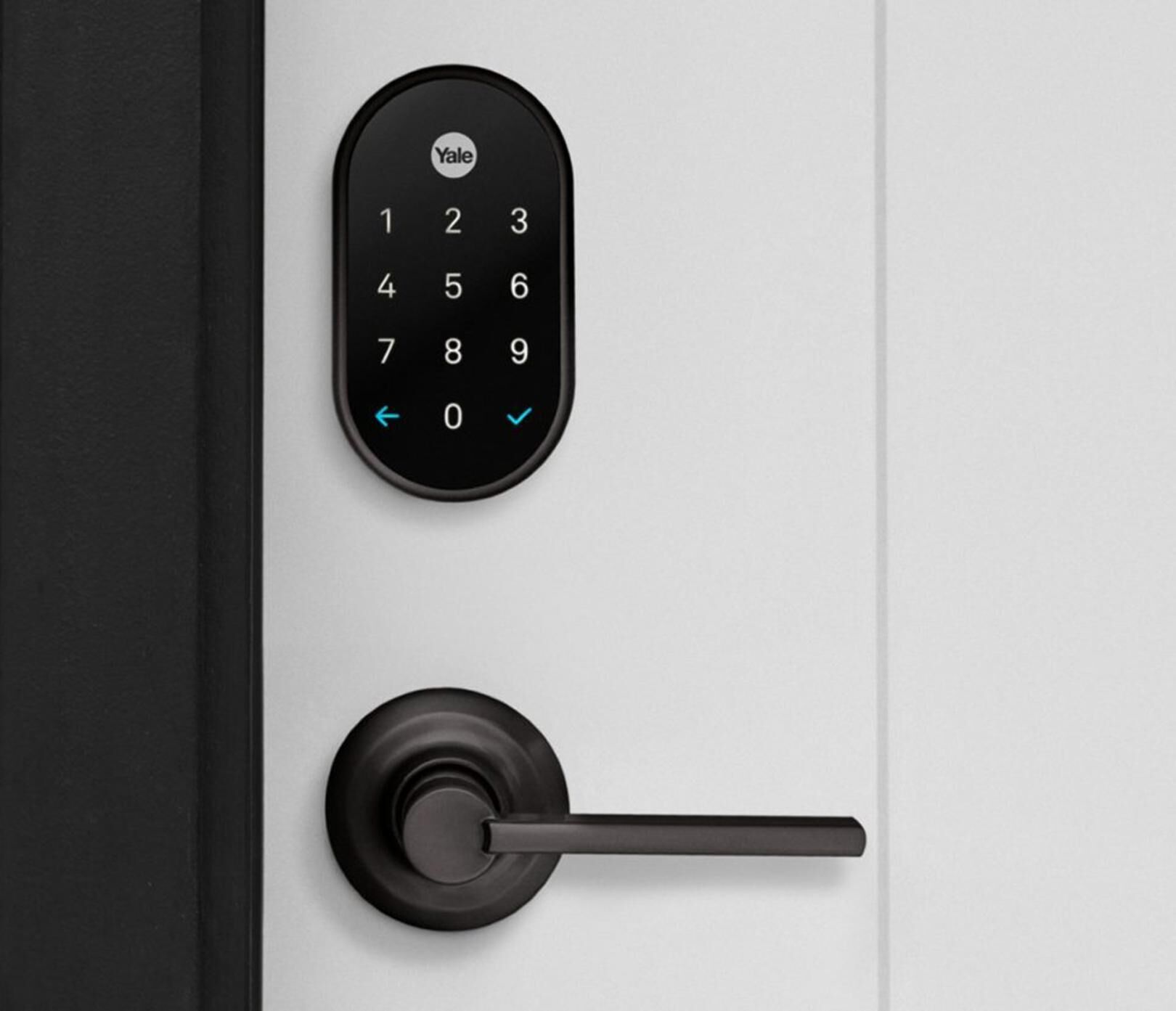 A Yale smart lock and a door handle on a white door.