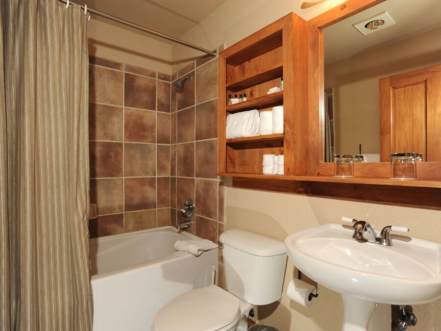 A bathroom with a bathtub, toilet, and sink.