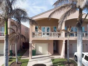 Stunning two-story residence with a central entrance, flanked by upper-floor windows and a balcony with a railing.