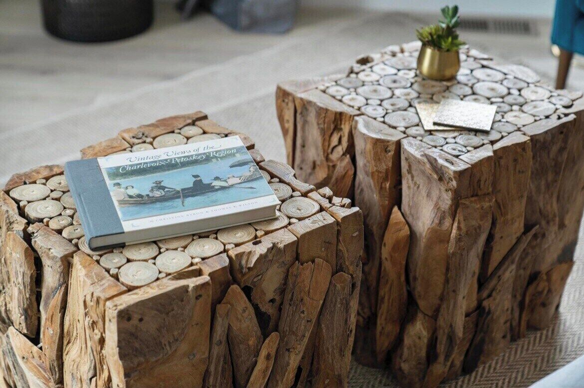 Ein Holztisch mit einem Buch mit dem Titel "Vintage Vibes of the Region" und einem kleinen Topfpflanzen.
