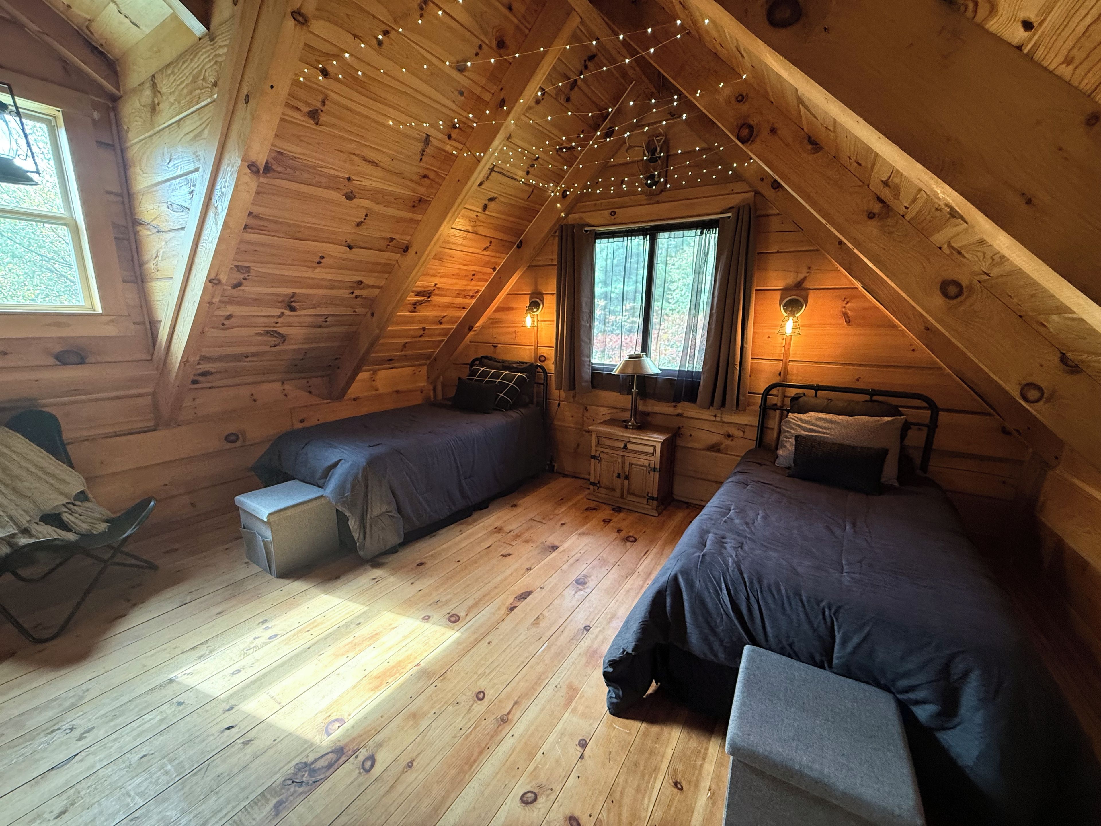 Een knus slaapkamer op zolder met twee bedden, een tafeltje en een stoel.
