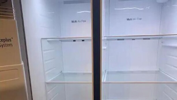 A transparent refrigerator with multiple air flow labels and a visible control panel.