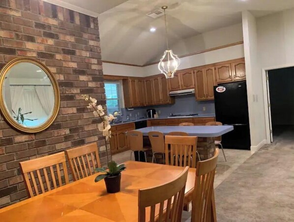 Enjoy meals in the kitchen with an island and dining area featuring a wooden table and chairs.