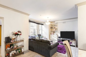 Apartamento básico, 1 cama Queen | Área de estar | TV