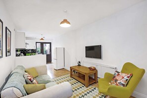 Apartamento básico, 1 cama Queen | Área de estar | TV