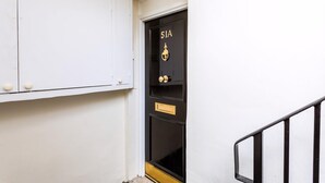 A black door with the number 51A, a brass knocker, and a brass handle.