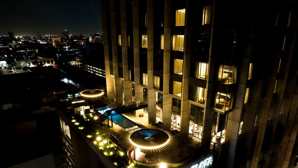 Un edificio de gran altura con piscina en la azotea y un letrero que dice "GALERIA PLAZA".