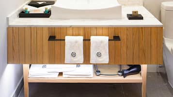 Un baño moderno con tocador de madera, un espejo grande y un lavamanos blanco.