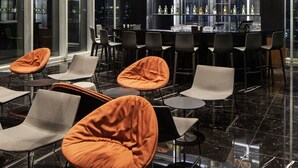 Un bar moderno con asientos y una vitrina de botellas.