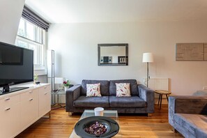 Departamento básico, varias camas | Área de sala de estar | Televisión 