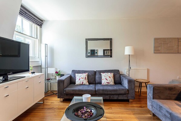 Apartamento básico, várias camas | Área de estar | TV