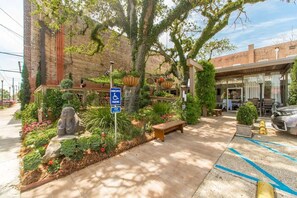 Enjoy the serene outdoor space with a bench and statue, surrounded by lush landscaping.