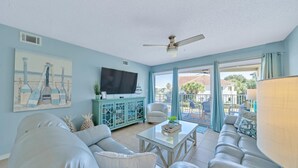 Una sala de estar con sofá, televisión y mueble.
