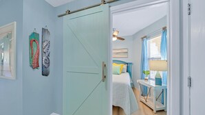 Un dormitorio con cama, mesita de noche y ventana con cortinas.