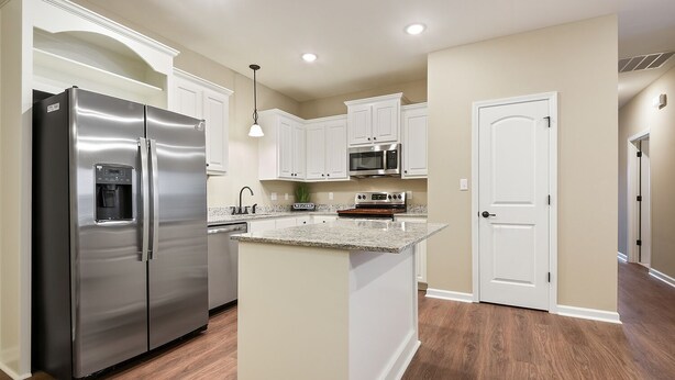 A modern kitchen with a stainless steel refrigerator, granite countertop, white cabinetry, and a built-in oven. - Minutes from LSU, SU, & Downtown Baton Rouge! (Brusly)