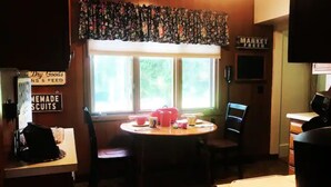 A room with a round table, chairs, a window with a view, a sign reading "Market Fresh", and a sign for "Dry Goods". - The Gathering Place, rent the entire home (Erie)