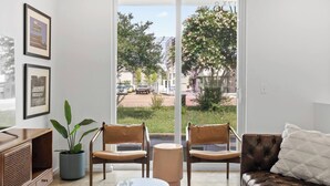 A modern living room with a sofa, two chairs, a small table, and a potted plant. - South Side Modern | Downtown Living | A+ Location., South Side Modern | Downtown Living | A+ Locatio (Chattanooga)